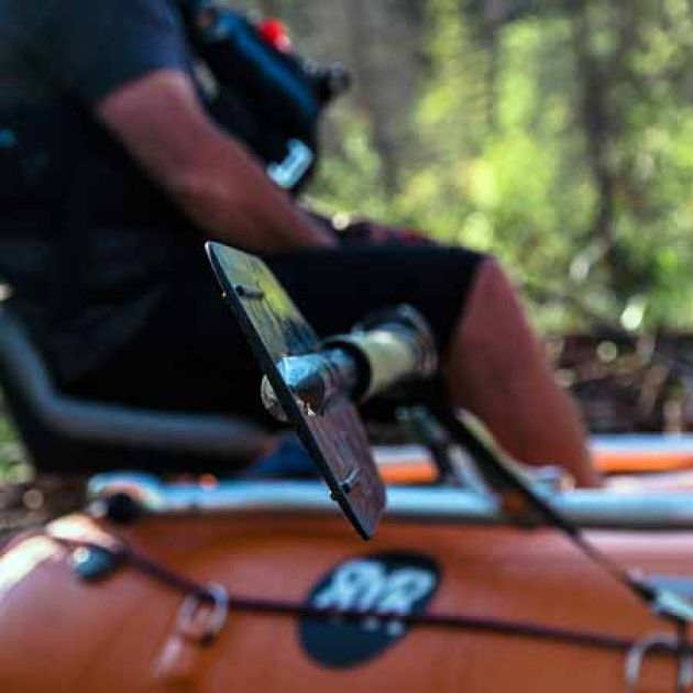 Guide with oar on an orange raft.