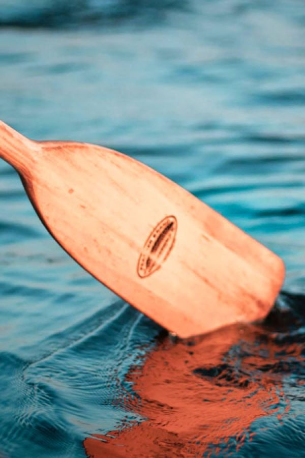 Guide with oar on an orange raft.