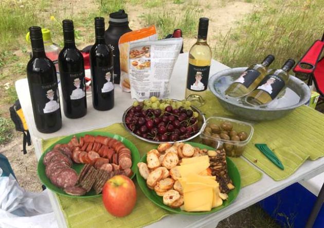 Wines, meats and cheeses displayed on a table.