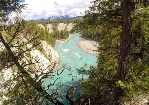 Overlooking a river from the riverbank with two red rafts